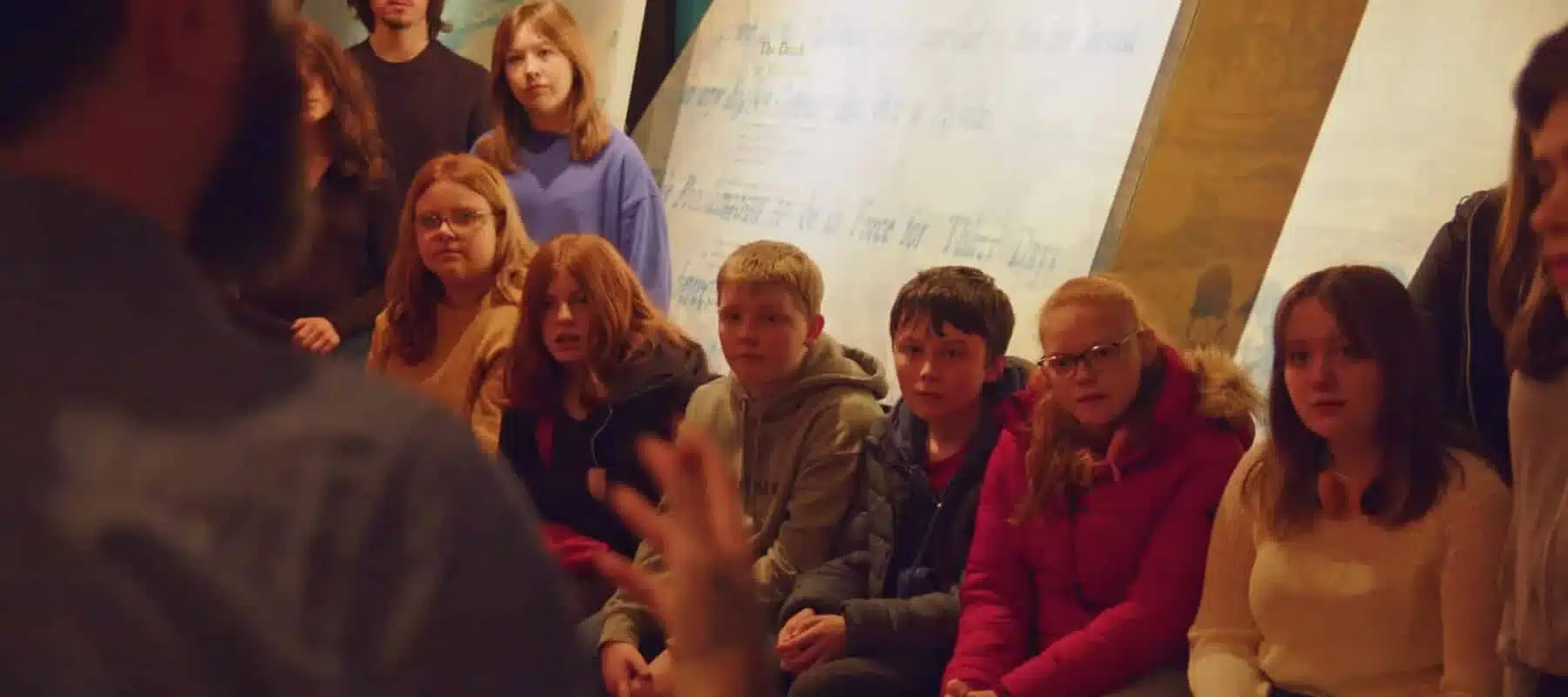 Group of children listening to a guide during an indoor educational session at Enniscorthy Castle.