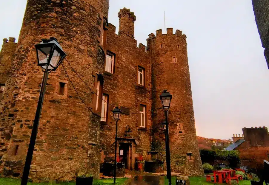 Evening view of Enniscorthy Castle’s exterior with warm lighting, lampposts and the surrounding grounds.