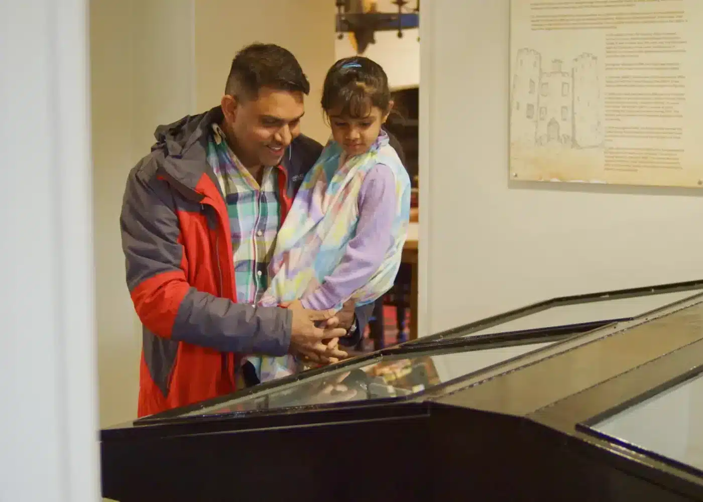 Man and child looking at an indoor display case together in Enniscorthy Castle’s exhibition area.
